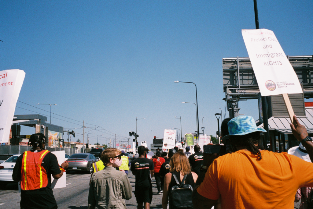 The back sides of people marching the streets of LA